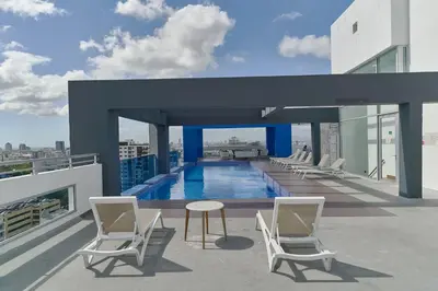 a balcony with chairs and a pool on a building at N1001 Gran vista Downtown Santo Domingo RD in Santo Domingo