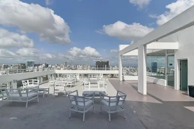 a patio with white chairs and tables on a roof at N1001 Gran vista Downtown Santo Domingo RD in Santo Domingo
