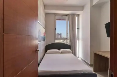 a small room with a bed and a window at N1001 Gran vista Downtown Santo Domingo RD in Santo Domingo
