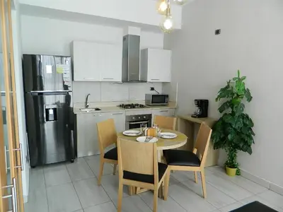 a kitchen with a table and chairs and a refrigerator at N1001 Gran vista Downtown Santo Domingo RD in Santo Domingo