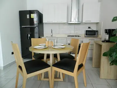 a kitchen with a table with chairs and a refrigerator at N1001 Gran vista Downtown Santo Domingo RD in Santo Domingo