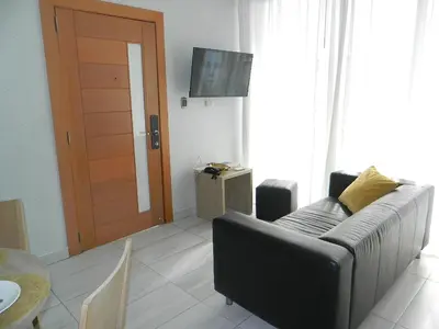 a living room with a couch and a wooden door at N1001 Gran vista Downtown Santo Domingo RD in Santo Domingo