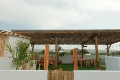 a wooden pergola with a table and chairs at Kite House Cabarete across Kite Beach in Cabarete