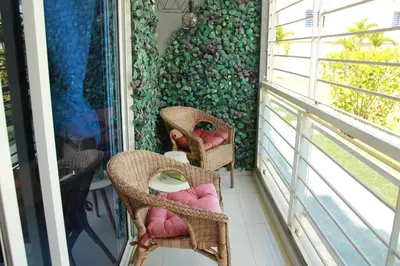 a balcony with wicker chairs and a wall with a window at Las Cayenas Residéncial in Santo Domingo