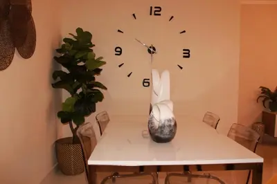 a white table with a clock on the wall at Las Cayenas Residéncial in Santo Domingo