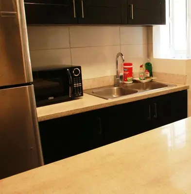 a kitchen with a sink and a microwave at Las Cayenas Residéncial in Santo Domingo
