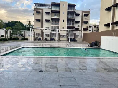 a swimming pool in front of a building at Apartamento Esme in Santo Domingo