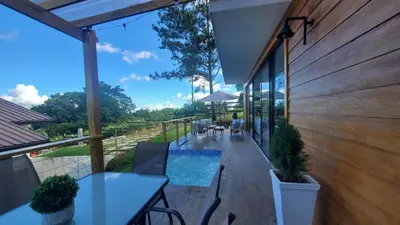 a patio with tables and chairs and a swimming pool at Villa en la montaña in Jarabacoa
