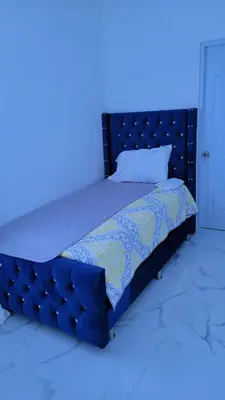 a bed in a blue room with a blue light at Madome Aparta Hotel in Pedernales