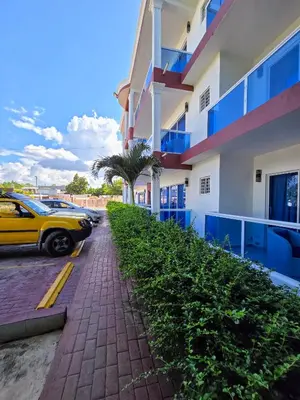 a yellow car parked next to a building at Madome Aparta Hotel in Pedernales
