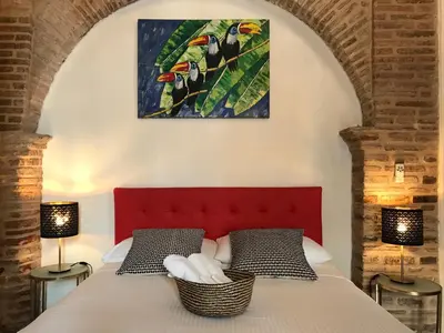 a bedroom with a bed with a red headboard and two lamps at Paseo Colonial - Sabbatical #1 in Santo Domingo