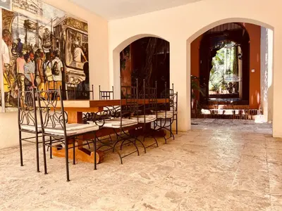 a room with chairs and paintings on the wall at Paseo Colonial - Sabbatical #1 in Santo Domingo