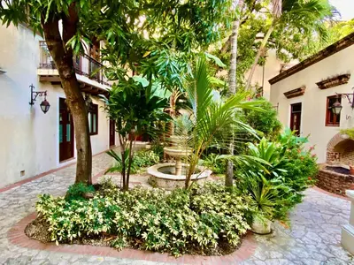 a courtyard with a fountain and trees and plants at Paseo Colonial - Sabbatical #1 in Santo Domingo