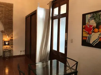 a dining room with a glass table and a painting at Paseo Colonial - Sabbatical #1 in Santo Domingo