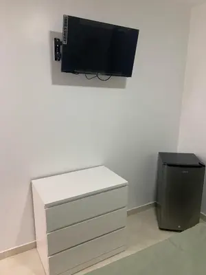 a tv sitting on a wall next to a dresser at Hotel Conquistador Santo Domingo in Santo Domingo