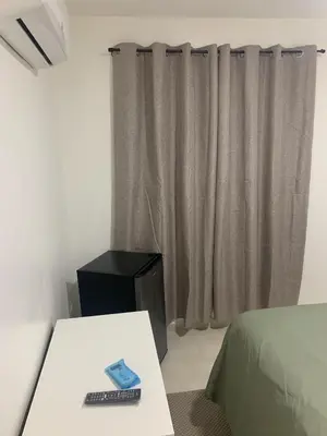 a bedroom with a bed and a table with a remote control at Hotel Conquistador Santo Domingo in Santo Domingo