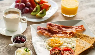 a table with two plates of breakfast food and a cup of coffee at Hotel Conquistador Santo Domingo in Santo Domingo