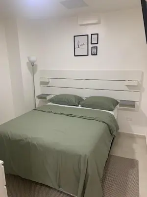 a bedroom with a large bed with a white wall at Hotel Conquistador Santo Domingo in Santo Domingo