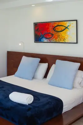 a bedroom with two beds and a painting on the wall at Beachfront penthouse - Amar'e Aparthotel & Spa in Las Terrenas