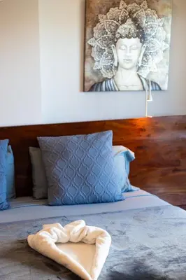 a bed with a towel laying on top of it at Beachfront penthouse - Amar'e Aparthotel & Spa in Las Terrenas