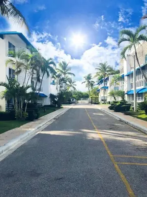 an empty street with palm trees and buildings at Acceso Exclusivo A Club De Playa Totalmente Gratis, Areas Sociales Con BBQ, Piscina, Jacuzzi, Gazebos, Baños, Ducha Exterior, Wifi, Netflix Y Al Lado De Minimarkets, Restaurantes, Bares, Tiendas, Campos De Golf, Hoteles, Bancos Comerciales, Etc in Guayacanes