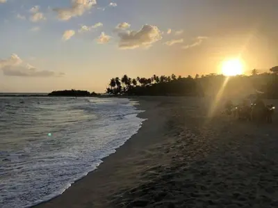 a beach with the sun rising over the ocean at Acceso Exclusivo A Club De Playa Totalmente Gratis, Areas Sociales Con BBQ, Piscina, Jacuzzi, Gazebos, Baños, Ducha Exterior, Wifi, Netflix Y Al Lado De Minimarkets, Restaurantes, Bares, Tiendas, Campos De Golf, Hoteles, Bancos Comerciales, Etc in Guayacanes