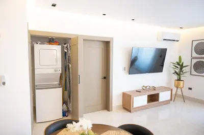 a living room with a refrigerator and a table at Top Floor in Luxury Tower in Santiago de los Caballeros
