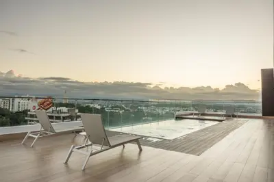 a balcony with two chairs and a pool on a building at Top Floor in Luxury Tower in Santiago de los Caballeros