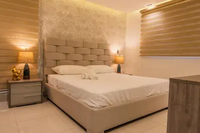a bedroom with a large bed and two lamps at Top Floor in Luxury Tower in Santiago de los Caballeros
