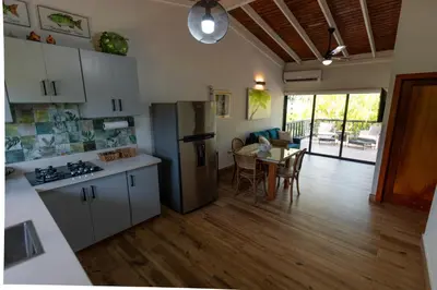 a kitchen and living room with a table and a refrigerator at Beach Apartment Villas Jubey, Emotion access in Juan Dolio
