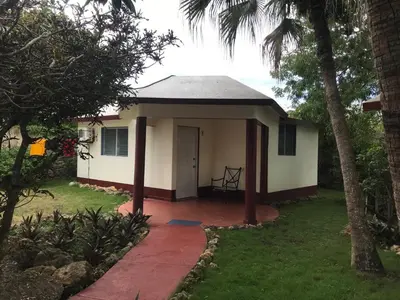 a small white house with a porch at Hacienda de Flores in Guayacanes