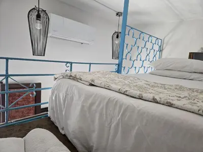 a bed with a blue headboard in a room at Colonial apartment for up to 4 person in Santo Domingo