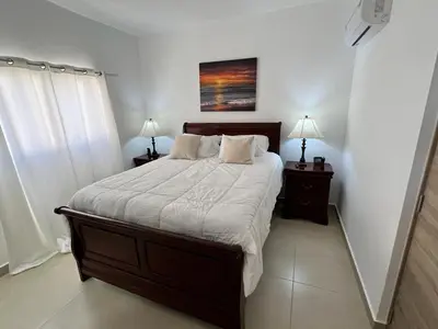 a bedroom with a large bed with two night stands at Armonia De Las Terrenas Gorgeous Penthouse in Las Terrenas