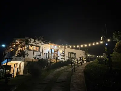 a building with lights on it at night at La Casita de Charo 1, disfruta de tiempo memorable en la montaña in Constanza