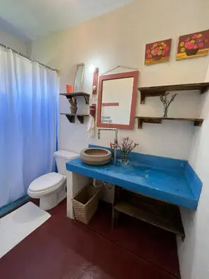a bathroom with a blue sink and a toilet at La Casita de Charo 1, disfruta de tiempo memorable en la montaña in Constanza