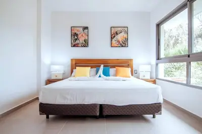 a bedroom with a large bed and two windows at 3 Bedroom Pool Villa 50M To The Beach in Las Terrenas