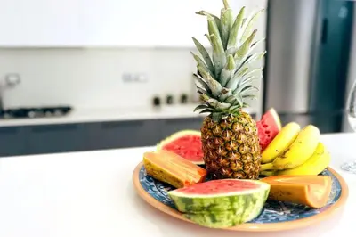 a plate with a pineapple and other fruits on a counter at 3 Bedroom Pool Villa 50M To The Beach in Las Terrenas