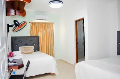 a hotel room with two beds and a window at Hotel las Nina in Paraíso