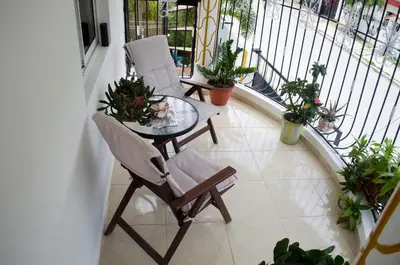 a balcony with two chairs and a table and some plants at Hotel las Nina in Paraíso