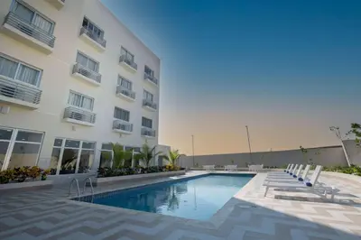 a swimming pool in front of a building at Super 8 by Wyndham Manzanillo in Pepillo Salcedo