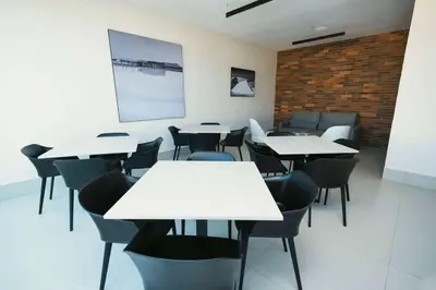 a classroom with white tables and chairs and a brick wall at Super 8 by Wyndham Manzanillo in Pepillo Salcedo