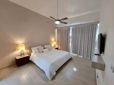 a bedroom with a white bed and a ceiling fan at Golf & Lake View Oasis •Private Jacuzzi •Hard Rock in Punta Cana