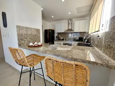 a kitchen with two chairs and a counter top at Golf & Lake View Oasis •Private Jacuzzi •Hard Rock in Punta Cana