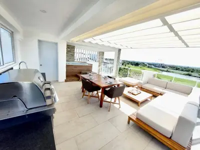a kitchen and living room with a couch and a table at Golf & Lake View Oasis •Private Jacuzzi •Hard Rock in Punta Cana