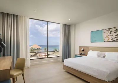 a bedroom with a bed and a view of the ocean at Hilton Garden Inn La Romana in La Romana