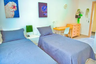 two beds in a room with a desk and a table at Marina Bay in Las Terrenas