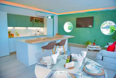 a kitchen and a living room with a table and chairs at Marina Bay in Las Terrenas