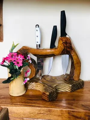 a knife holder on a table with a vase of flowers at Rustic House Punta Rucia in Punta Rucia