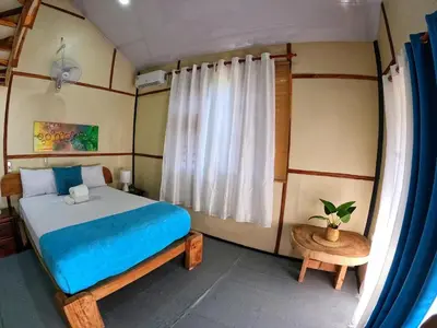 a bedroom with a large bed and a window at Rustic House Punta Rucia in Punta Rucia