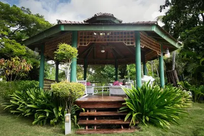a gazebo with a wooden deck in a garden at Fontana di Rosa, African Style Villa Casa de Campo in La Romana
